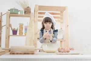 söt unge tycker om att förbereda degen för att göra en tårta i köket room.photo serie av lycklig familj koncept. foto