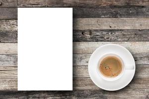 platt lägg espressokaffe i kaffekopp och vitt blankt papper med kopieringsutrymme på träbordsbakgrund. foto