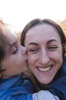 pojke pussar och kramar mamma, lyckligt moderskap foto