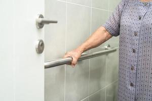 asiatisk äldre eller äldre gammal dam kvinna patienten använder toalett badrum handtag säkerhet i vårdavdelningen, friska starka medicinska koncept. foto