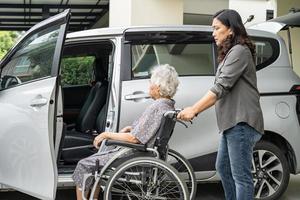 hjälp och stöd asiatiska senior eller äldre gammal dam kvinna patienten förbereder sig till sin bil. foto