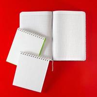 kontorsmateriel - anteckningsböcker på en röd bakgrund. foto