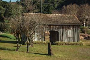 bento goncalves, Brasilien - 11 juli 2019. gammalt trähus i traditionell lantlig stil med en välskött trädgård och träd, nära bento goncalves. foto