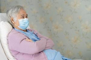 asiatisk senior eller äldre gammal damkvinna som bär en ansiktsmask ny normal på sjukhus för att skydda säkerhetsinfektion covid-19 coronavirus. foto