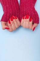 röd matt manikyr på kvinnliga händer i tröja för alla hjärtans dag foto