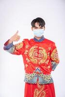 man bär cheongsam kostym och mask visar det bästa sättet att handla för att skydda sjukdom foto