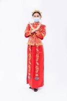 kvinna bär cheongsam kostym och mask show folk inte bär mask kan inte komma för att handla på kinesiska nyåret foto