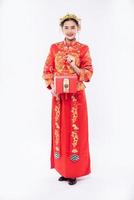 kvinna bär cheongsam kostym leende för att visa den stora utmärkelsen från företagets spel i kinesiska nyåret foto