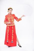 kvinna bär cheongsam kostym och svart sko glad att få nya saker för att överraska i kinesiska nyåret foto