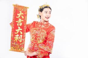 kvinna bär cheongsam kostym ge familjen det kinesiska gratulationskortet för lycka i kinesiska nyåret foto