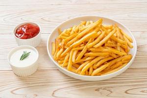 pommes frites med gräddfil och ketchup foto