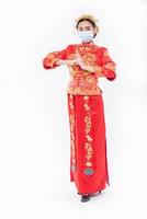 kvinna bär cheongsam kostym och mask respekterar sin far och mor i kinesiska nyåret foto