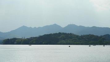 de vackra sjölandskapen i hangzhou-staden i Kina på våren med den fridfulla sjön och de friska gröna bergen foto