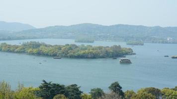 de vackra sjölandskapen i hangzhou-staden i Kina på våren med den fridfulla sjön och de friska gröna bergen foto