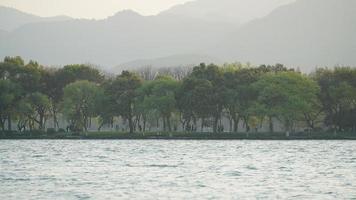 de vackra sjölandskapen i hangzhou-staden i Kina på våren med den fridfulla sjön och de friska gröna bergen foto