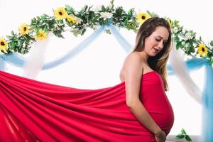 ung vacker gravid kvinna poserar. tittar på hennes mage foto
