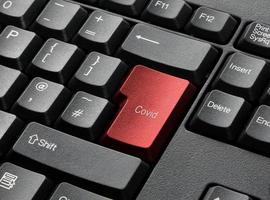 ett svart tangentbord med röd covid-nyckel foto