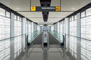 modern gångväg med rulltrappa framåt och rulltrappa bakåt på den internationella flygplatsen. rulltrappan är en facilitet för att stödja transport i modern byggnad foto