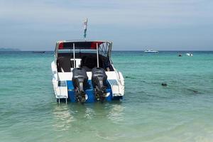 båt med två motorer på kajen nära stranden. foto