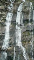 den vackra utsikten över landskapet med vattenfallet som rinner i bergen efter den regniga dagen foto