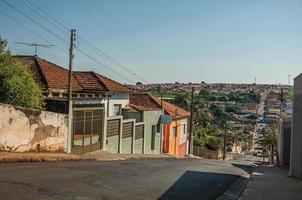 sao manuel, brasilien, 14 oktober 2017. downhill street view med trottoarväggar och färgglada hus en solig dag på sao manuel. en söt liten stad på landsbygden i delstaten Sao Paulo. foto