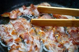 steka bacon i en förvärmd panna. foto