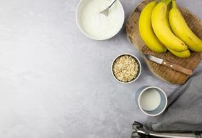 beredning av en banancocktail med naturlig yoghurt och havregryn. toppvy. foto