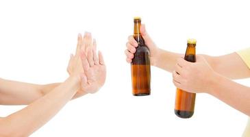 hand avvisa en flaska öl isolerad på vit bakgrund, anti alkohol koncept. kopiera utrymme, mock up, sociala program foto