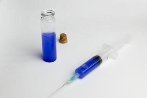 kolven och sprutan med blå lösning i laboratorievetenskap. foto