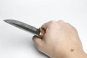 hand på en vit bakgrund som håller en kniv. foto