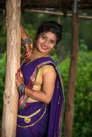 vacker indisk ung flicka i traditionell saree poserar utomhus foto