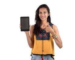 ung vacker kvinna med tom skärm smart telefon på vit bakgrund foto