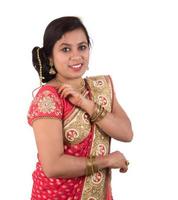 vacker ung flicka poserar i indisk traditionell saree på vit bakgrund. foto