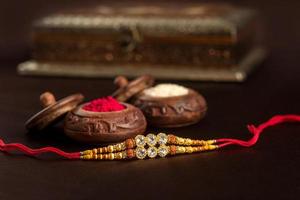 indisk festival raksha bandhan bakgrund med en elegant rakhi, riskorn och kumkum. ett traditionellt indisk armband som är en symbol för kärlek mellan bröder och systrar. foto