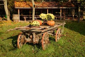 trävagn med höstfrukter. höstens skördefest - gammal vagn med pumpor. foto