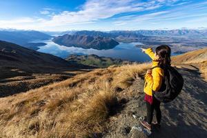 ung asiatisk resenär ryggsäck vandring på roys peak track, wanaka, södra ön, Nya Zeeland foto