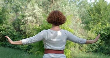 kvinna som utövar qigong och meditation i sommarparken eller skogen foto