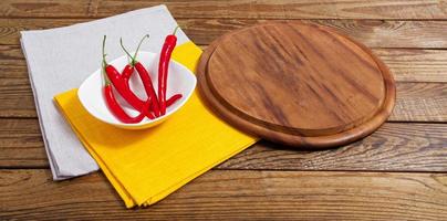 tom bräda och röd peppar på ett tomt bord foto