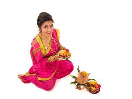 traditionell indisk flicka som utför tillbedjan med kopparkalash, indisk festival, kopparkalash med kokosnöt och mangoblad med blomdekor, väsentligt i hinduisk puja. foto