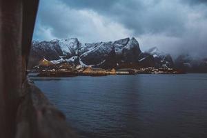 norge rorbuhus och berg klippor över fjordlandskap skandinavisk resevy lofoten öar. naturligt skandinaviskt landskap. foto