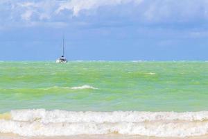 vackra holbox ön strand turkost vatten vågor och båtar Mexiko. foto