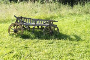 gammal trävagn står på gräset. foto