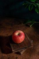 äpplena på tallriken ser ut som oljemålningar under det svaga ljuset på träfibrernas bord foto