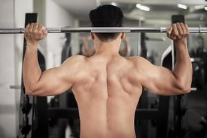 bodybuilder man med stor muskulös rygg i gymmet