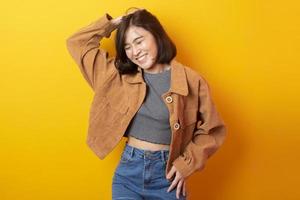 vacker asiatisk kvinna universitetsstudent glad på gul bakgrund