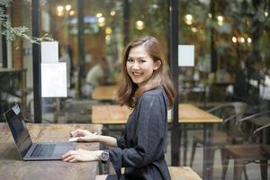smart asiatisk kvinna arbetar med bärbar dator