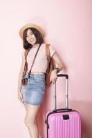 glad asiatisk kvinna turist på rosa bakgrund