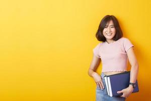 vacker asiatisk kvinna universitetsstudent glad på gul bakgrund