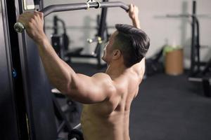 bodybuilder man med stor muskulös rygg i gymmet foto