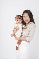 asiatisk mamma och bedårande flicka är glada på vit bakgrund foto